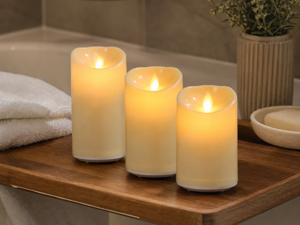 flameless candles for bathroom decor on a dry wooden tray beside folded towels